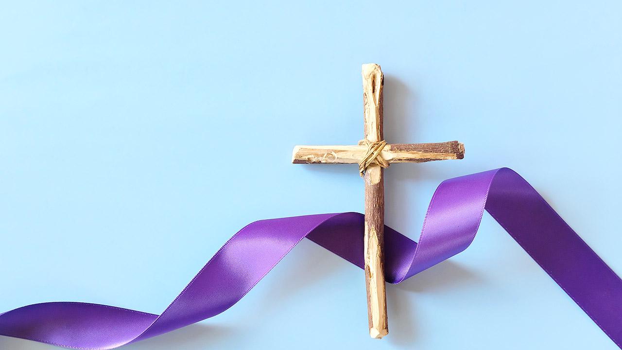 Kreuz mit violettem Band