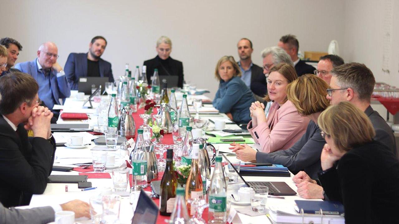 Konferenz Teilnehmende an einem Konferenztisch