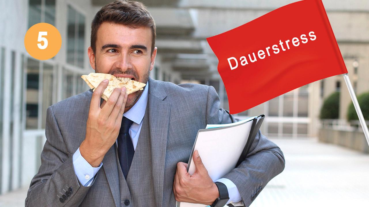 Stress Ein Mann im Anzug hetzt an einem Bürogebäude entlang und isst Pizza