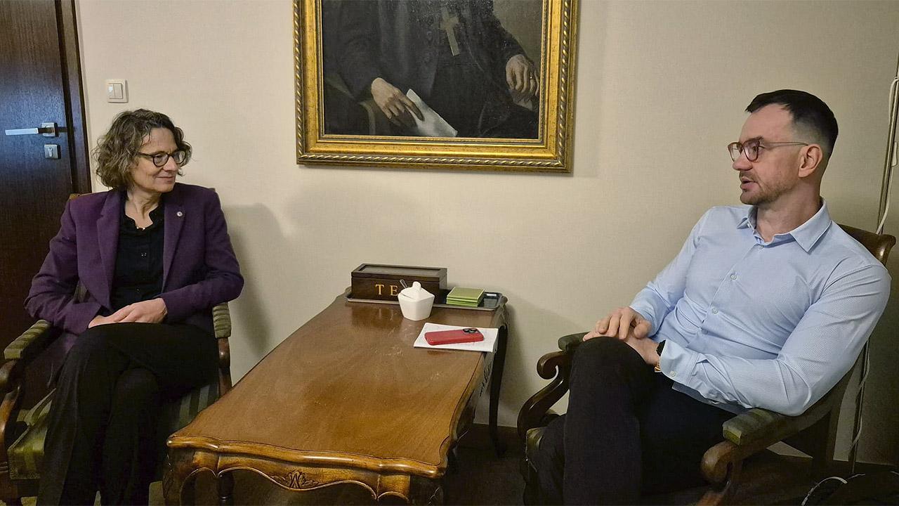 Polenreise Interview Christiane Tietz wird von einem Mann interviewt, dazwischen ein Tisch