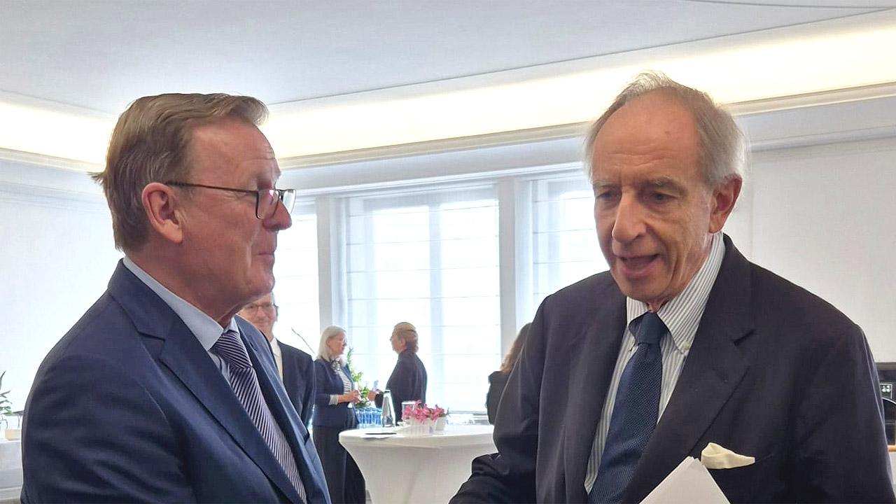 Zwei Männer begrüßen sich beide im Anzug