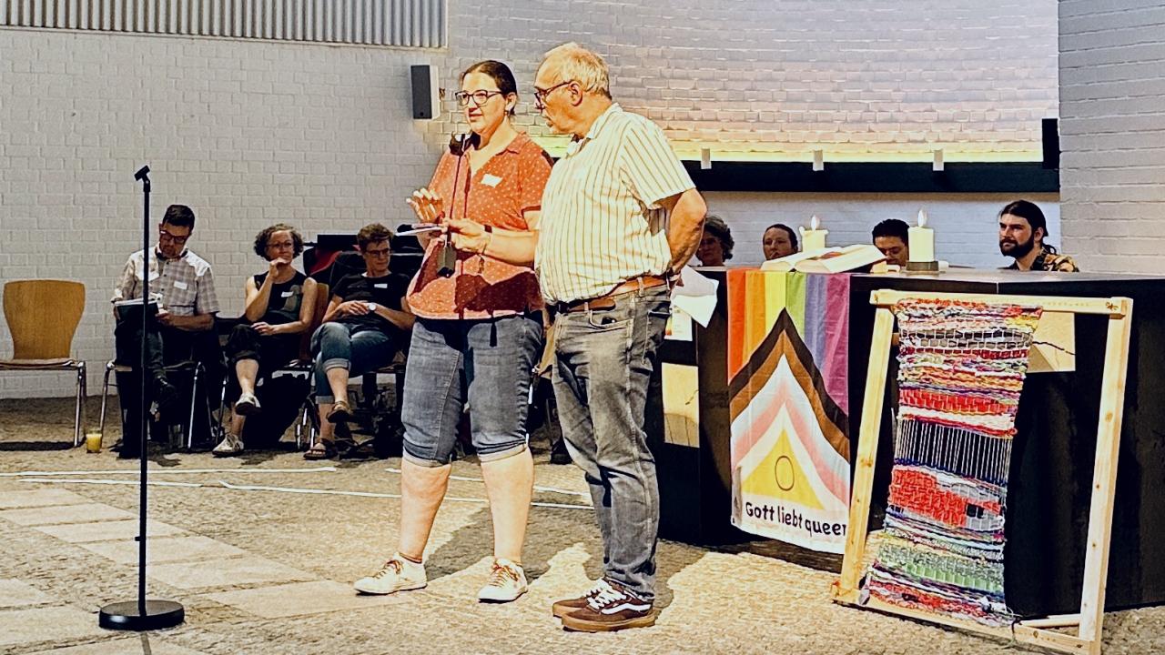 Moderation queersensibles Netzwerktreffen Lutz Neumeier und Jessica Hamm mit Mikrofon.