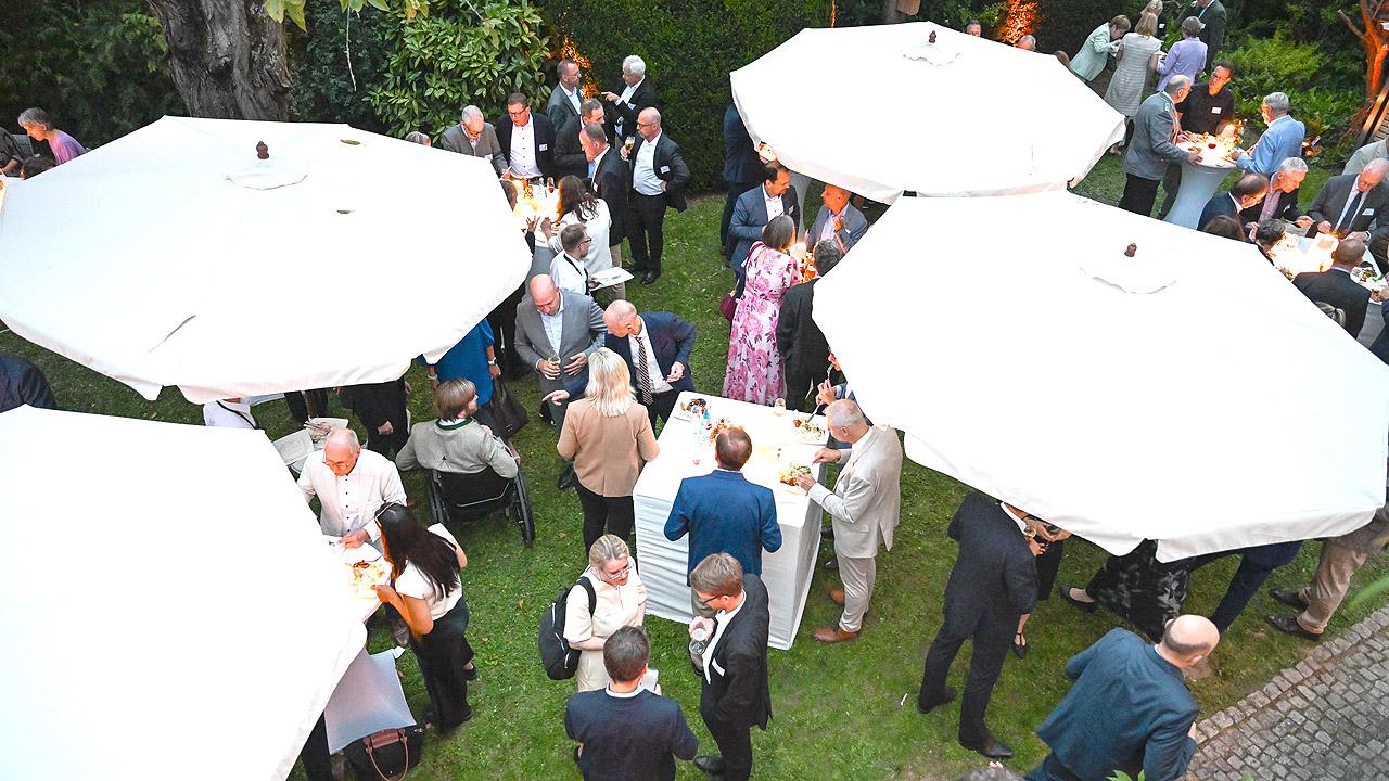 Menschen unter großen, weißen Schirmen