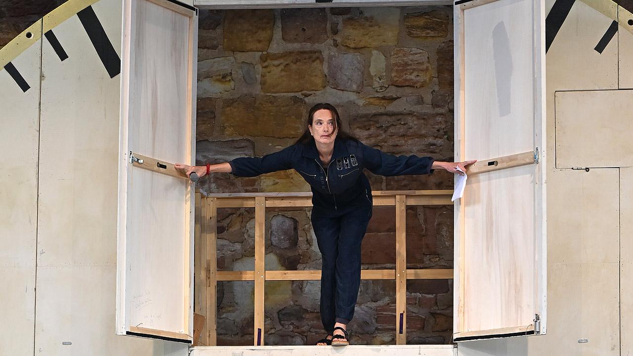 Ein Schauspieler öffnete eine Tür ein einer überdimensionalen Uhr