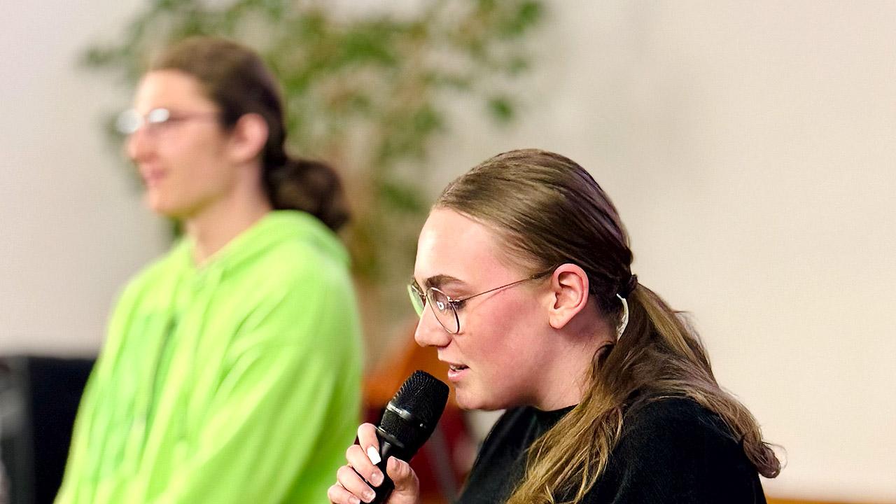 Junge Rednerin mit Mikrofon