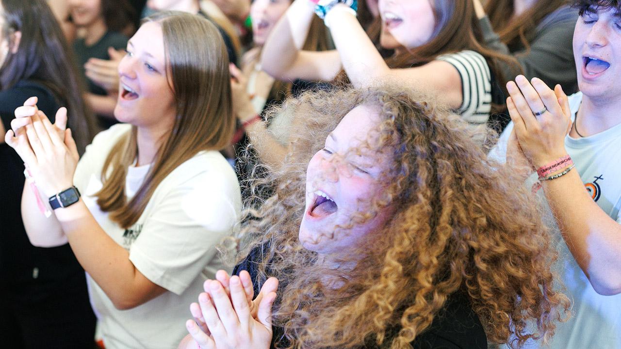 Jugendkirchentag Ein Mädchen mit vielen Locken freut sich und klatscht in die Hände