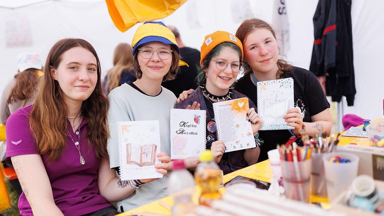 Blible Art Journaling Drei Mädchen präsentieren ihre kreativ gestalteten Bibeltexte