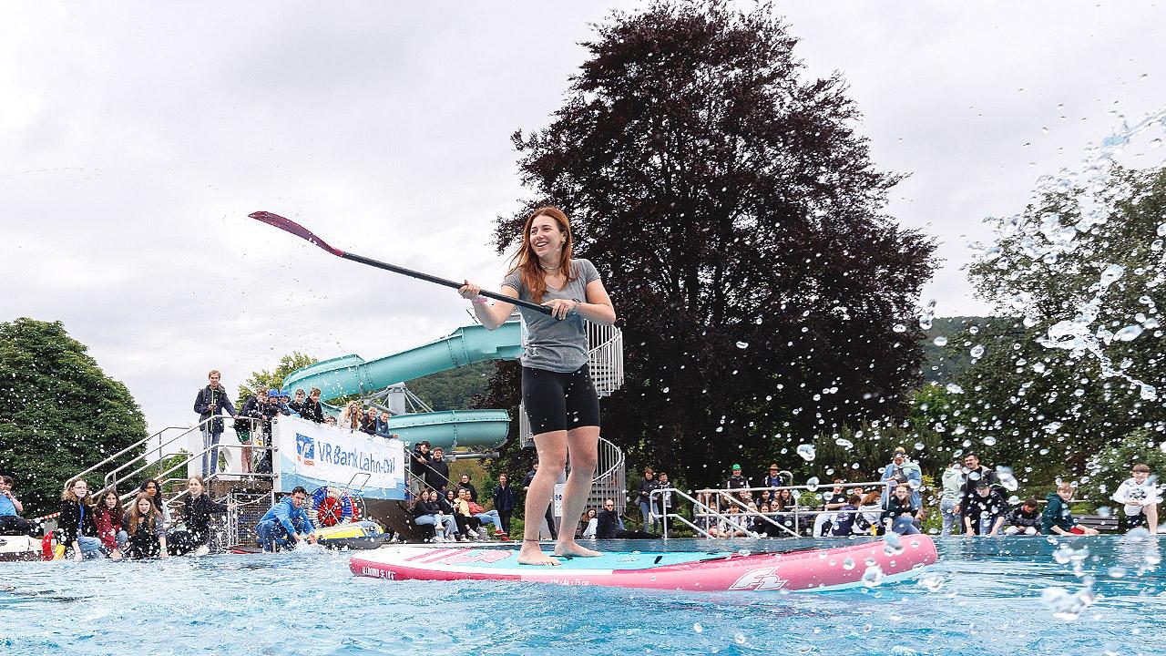 Jugendkirchentag Junge Frau auf Paddleboard im Schwimmbad