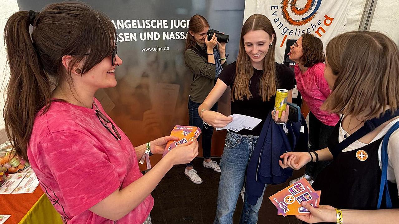 Kirchenvorstandswahl 2027 Junge Frauen an einem Stand der Evangelischen Jugend