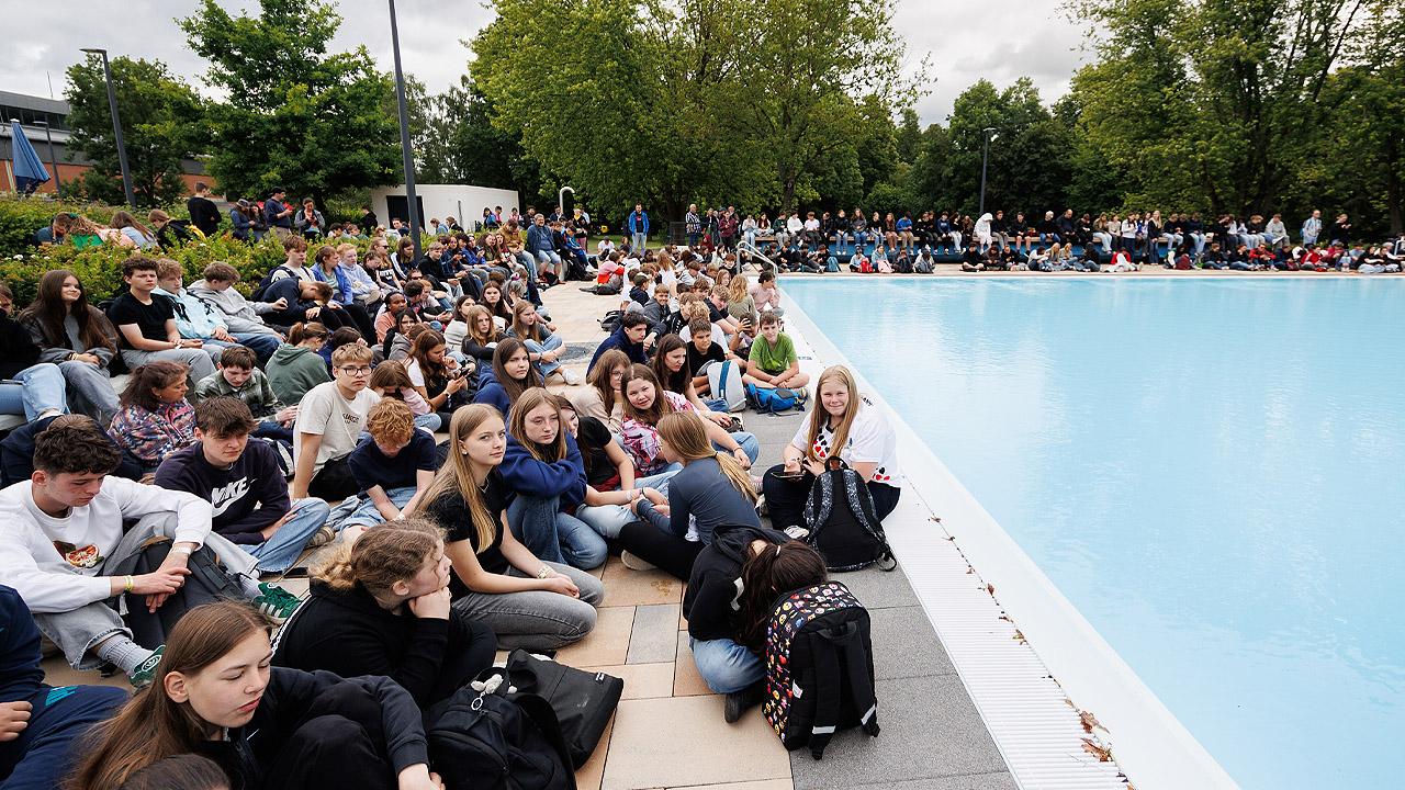 Schwimmbadgottesdienst Freibad und viele Jugendliche am Beckenrand