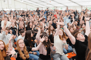 Jubelnde Jugendliche beim Jugendkirchentag in einem Festzelt