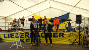 Pfarrerin und Gemeindepädagogin im Festzelt, im Hintergrund Musiker
