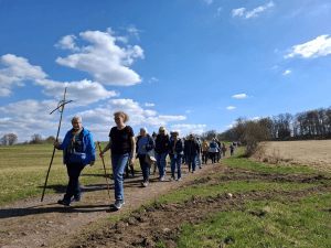 Menschen laufen auf einer Strecke mit einem Kreuz