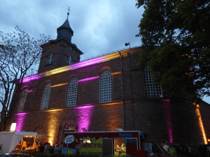 Außenansicht der Kirche mit bunten Lichtern angestrahlt